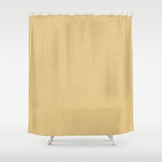 a shower curtain with yellow and white striped fabric on the bottom, in front of a gray background