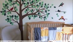 a baby's room with a tree painted on the wall