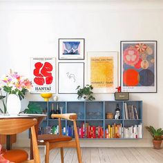 a living room filled with furniture and pictures on the wall above it's bookshelf