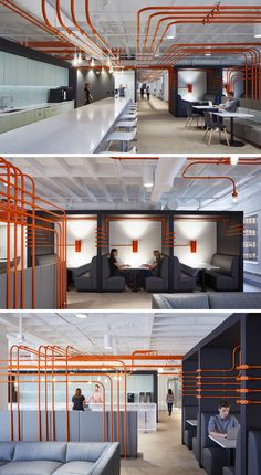 this office has orange pipes running from the ceiling to the floor, and people are sitting at their desks