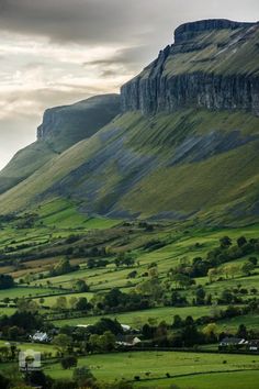 the mountains are covered in lush green grass