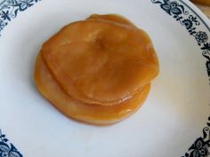 a small piece of food on a plate with blue and white designs around the edges