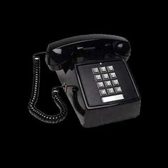 an old style phone with buttons on the front and back side, sitting against a black background