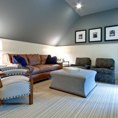 a living room filled with furniture and pictures on the wall