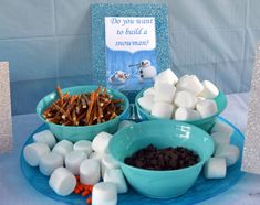 a table topped with bowls filled with marshmallows