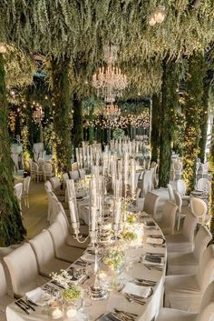 the table is set with white linens and place settings for guests to sit at