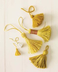 four tassels are arranged on a white surface, one is yellow and the other is red