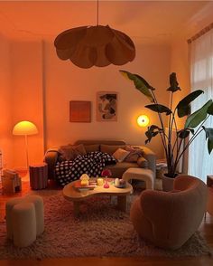 a living room filled with lots of furniture and plants in the middle of the room