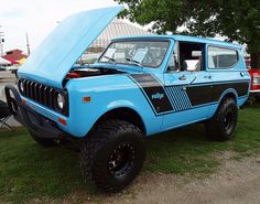 an old blue truck with its hood open