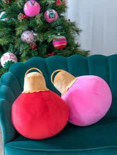 two christmas ornaments sitting on top of a green couch