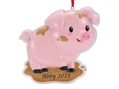 a pink pig ornament hanging from a red string