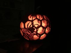 a carved pumpkin sitting on top of a table in the dark with spider webs