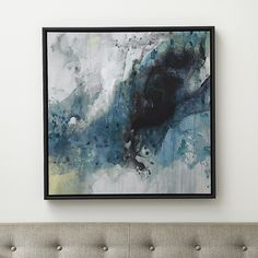 an abstract painting hangs on the wall above a couch in a room with white walls