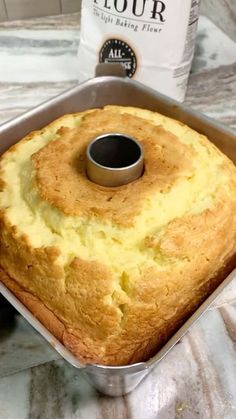 a bundt cake in a pan on a table next to a bottle of flour