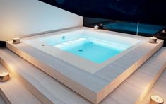 an indoor jacuzzi with candles around it