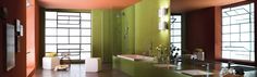 a bathroom with green walls and two sinks in the center, along with large windows