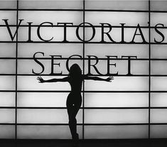 a woman standing in front of a sign that says victoria's secret