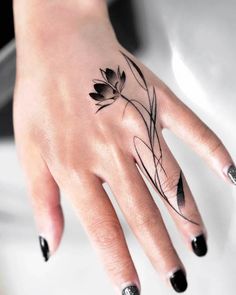 a woman's hand with black and white flowers on it