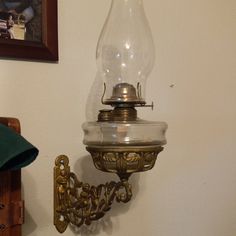 an old fashioned wall light with a glass shade hanging from it's back end