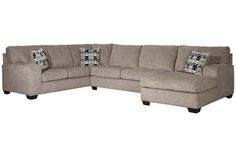 a large sectional couch with pillows on the top and bottom corner, in grey fabric