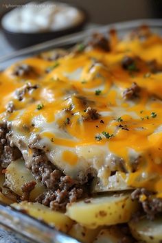 a casserole dish with meat, cheese and potatoes