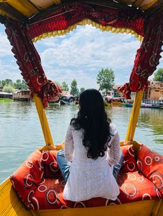 a woman is sitting in a boat on the water