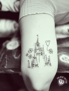 a black and white photo of a castle on the back of a woman's leg