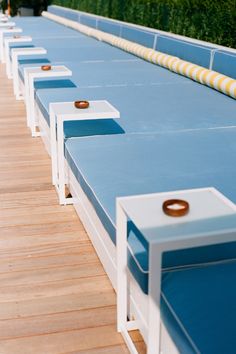 rows of blue and white benches lined up on the side of a wooden floored swimming pool