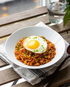 an egg sits on top of rice in a bowl