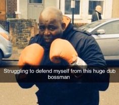 a man wearing boxing gloves standing in front of a car with the caption struggling to defend my self from this huge dub