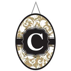 an oval sign with the letter c hanging from it's side, in black and gold