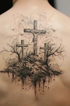 the back of a man's shoulder with three crosses and trees on top of it