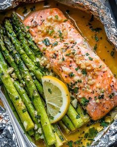 salmon and asparagus in foil with lemon wedges