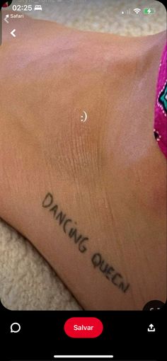 someone with a tattoo on their foot saying, dancing queen salavr is in the background