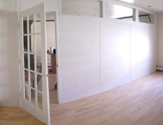 an empty room with white walls and wooden floors