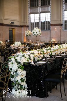 the tables are set up with black sequins and white flowers for an elegant reception