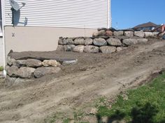 a large rock wall next to a house