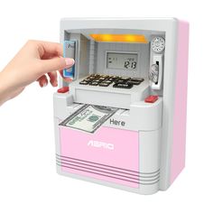 a pink and white atm machine with money in it's display case, being held up by a hand