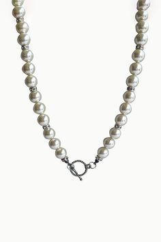 The Medici Pearl Necklace is a timeless classic with a modern twist. This beautiful necklace features ivory pearls interspersed with shiny zircon beads and an oxidized silver toggle clasp. Perfect for layering, you can wear this gorgeous necklace alone or add charms and pendants to the clasp for extra flair. Medici pearl necklace is perfect for any occasion and any neutral style. Ivory Shell Pearls Pearl: Love - Beauty - Wealth Zircon Spacer Beads Metal: Oxidized Sterling Silver Pearl Size: 10mm Silver Classic Beaded Necklace With Pearl Pendant, Classic Silver Beaded Necklaces With Pearl Pendant, Classic Silver Beaded Necklace With Pearl Chain, Elegant Round Beaded Necklaces With Sterling Silver Clasp, White Pearl Toggle Necklace With Pearl Pendant, White Pearl Toggle Necklace With Pearl Charm, Elegant White Toggle Necklace With Pearl Charm, Elegant Toggle Necklace With Sterling Silver Clasp, Elegant Toggle Necklace With Sterling Silver Clasp As Gift