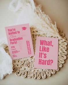 two pink graduation party cards sitting on top of a doily next to a white crochet doily