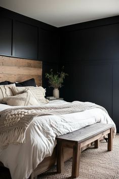 a bedroom with black walls and white bedding