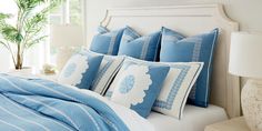 a bed with blue and white pillows on it