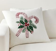 a white couch with a christmas decoration on it's back cushion and pillow cover