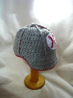 a crocheted baseball hat on a wooden stand