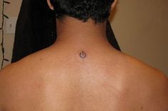 the back of a man's neck with a small circle tattoo on his left side