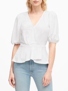 So charming.  This wrap-style top has a feminine peplum hem and billowing sleeves for a contemporary twist. Low v-neck. Elastic at back waist. Peplum hem. Semi-fitted. Short sleeves. Short body length - great with mid-rise and high-rise styles. Body length (size S): Regular 24'' Sleeve length from shoulder seam: Regular 14'' Model: Size XS, 5'10''  (178cm). Flowy V-neck Top For Work, Chic V-neck Blouse With Ruffle Hem, Spring V-neck Peplum Top With Ruffle Hem, Feminine Fitted V-neck Puff Sleeve Top, Chic V-neck Peplum Top With Ruffles, Spring Chic V-neck Peplum Top, Feminine V-neck Top With Ruffle Hem, White V-neck Puff Sleeve Top For Brunch, Elegant V-neck Peplum Top With Ruffles