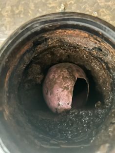 the inside of a metal pipe with dirt on it