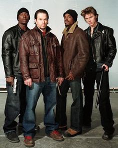 three men standing next to each other in leather jackets