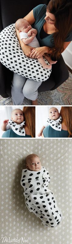 a woman holding a baby wrapped in a black and white polka dot print wrapper