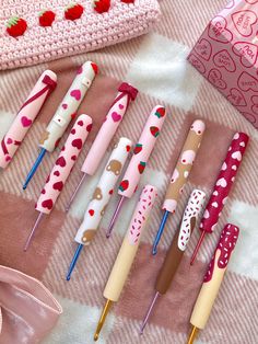 many different types of pens are lined up on a blanket with hearts and polka dots